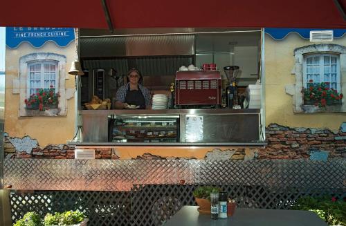 a woman is standing behind the counter of a restaurant at Maleny Hills Motel in Maleny