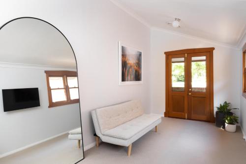a living room with a chair and a mirror at Kuzman Homestead in Mudgee