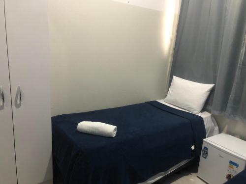 Ágape Hotel في ريو فيرد: غرفة صغيرة عليها سرير وفوط