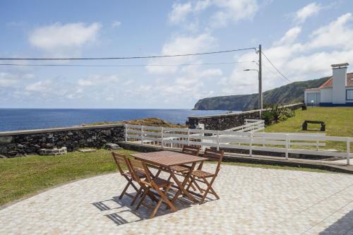 a table and chairs on a patio overlooking the ocean at Canto do Mar in Mosteiros