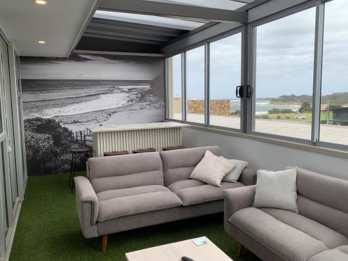 a living room with two couches and a view of the beach at Wyndham Resort Torquay in Torquay