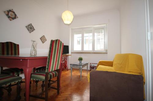 een woonkamer met een tafel en een gele bank bij WELCOME TO LISBOA in Lissabon