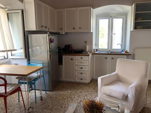 a kitchen with a refrigerator and a table and chairs at LaLuzaki in Spetses