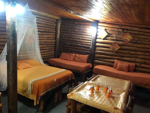 a room with two beds and a table in it at barro blanco turismo rural in Villa Achával