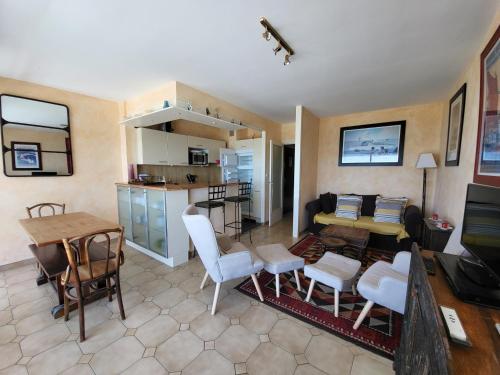 un salon avec une table et des chaises et une cuisine dans l'établissement Appart T3 avec parking, proche plage et commerces - FR-1-92-625, à Les Sables-dʼOlonne