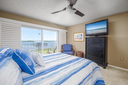 1 dormitorio con 1 cama grande y TV en Point Matanzas B3, en St. Augustine