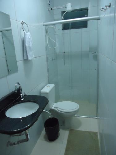 Un baño con lavabo, inodoro y ducha. en Hotel MM AEROPORTO BRASÍLIA, en Núcleo Bandeirante