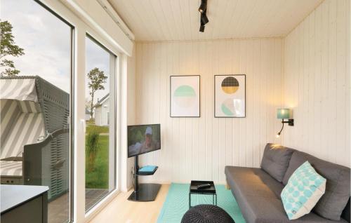 a living room with a couch and a large window at Sea You in Olpenitz
