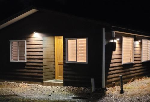 a house with a door and windows at night at Cabañas IBY y KIARA para 4 en Puerto Varas in Puerto Varas
