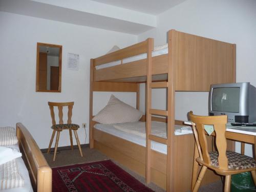 a bedroom with bunk beds with a desk and a computer at Wengerterstube & Gästezimmer Kern in Oberderdingen