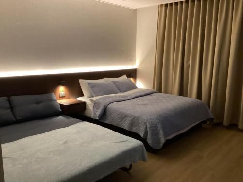 ein Hotelzimmer mit 2 Betten und einem Fenster in der Unterkunft Luxury Condo in Clark Pampanga beside Hilton Hotel and Casino in Angeles