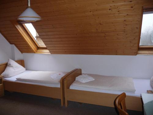 Bett in einem Zimmer mit Holzdecke in der Unterkunft Wengerterstube & Gästezimmer Kern in Oberderdingen