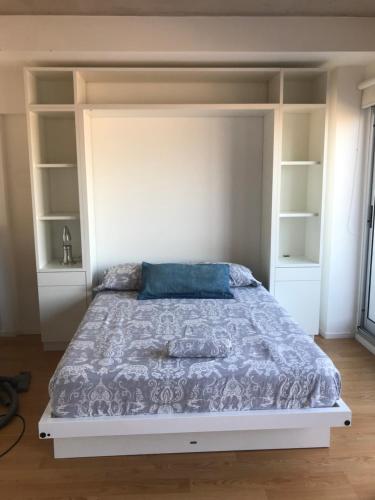 a bedroom with a large bed with white shelves at Monoambiente en La Boca. in Buenos Aires