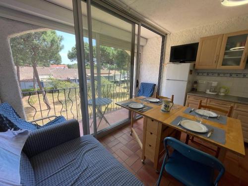 Il comprend une cuisine avec une table et un balcon. dans l'établissement Appartement Familial Proche Plage à Argelès-sur-Mer avec Balcon et Animaux Acceptés - FR-1-225-741, à Argelès-sur-Mer