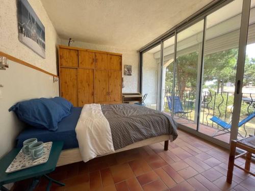 une chambre avec un grand lit et un balcon dans l'établissement Appartement Familial Proche Plage à Argelès-sur-Mer avec Balcon et Animaux Acceptés - FR-1-225-741, à Argelès-sur-Mer