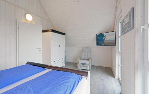 een slaapkamer met een bed, een tv en een stoel bij Nice Home In Ostseeresort Olpenitz With House Sea View in Olpenitz