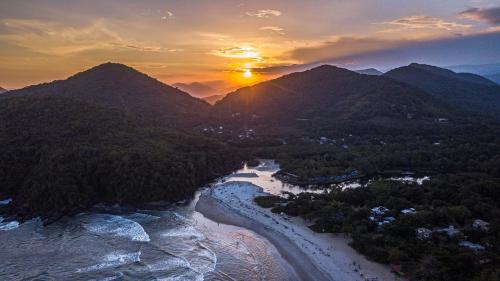 an aerial view of a river and mountains at sunset at Pousada e Hostel Marthi in Ubatuba