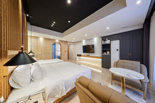 a bedroom with a large bed and a couch at Hotel Hiveinn in Gwangju
