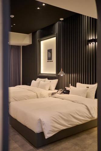 two large beds in a room with black walls at Hotel Hiveinn in Gwangju