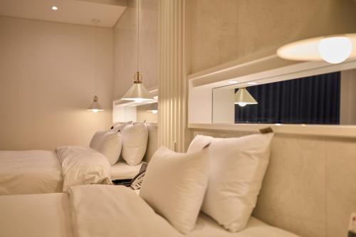 a living room with white pillows on a couch at Hotel Hiveinn in Gwangju