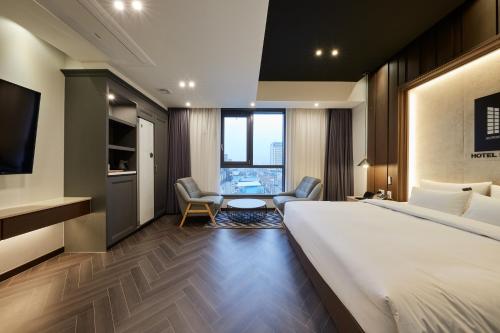 a hotel room with a bed and a table and chairs at Hotel Hiveinn in Gwangju