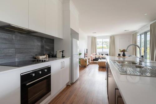a kitchen with white cabinets and a counter top at CASALE COTTAGE Barossa Valley in Nuriootpa