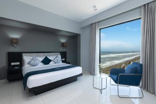 a bedroom with a bed and a view of the ocean at MaRadha Colombo in Colombo