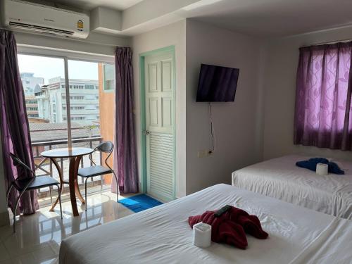 a hotel room with two beds and a balcony at Baanpak Sam Anong in Hua Hin