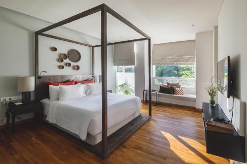 1 dormitorio con 1 cama blanca grande con dosel en Hu'u Villas, en Seminyak