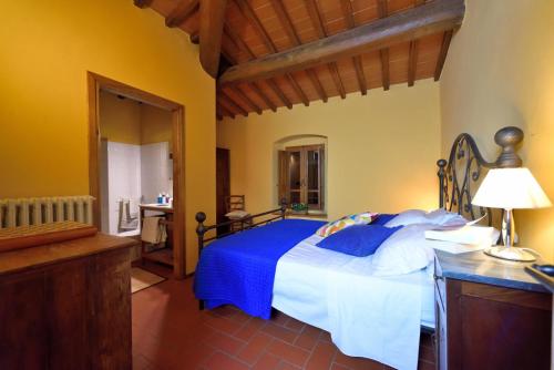 1 dormitorio con 1 cama grande con manta azul en Il Bellini - Tuscany farmholiday, en Pulicciano