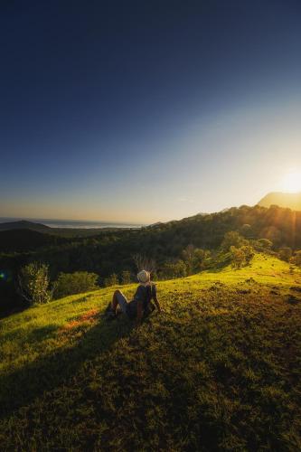 a person sitting on top of a grassy hill at Sumberkima Hill 2 in Pemuteran