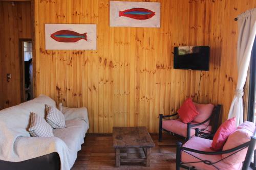 a living room with two couches and a tv at Cabaña El Mirador de Vichuquén in Vichuquén