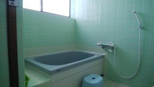 a bathroom with a bath tub and a mirror at Minshuku Marin - Vacation STAY 90965 in Higashikagawa