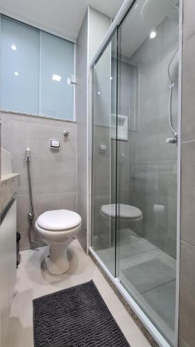 a bathroom with a toilet and a glass shower at MARAVILHOSO ESTÚDIO- PRAIA DE BOTAFOGO in Rio de Janeiro