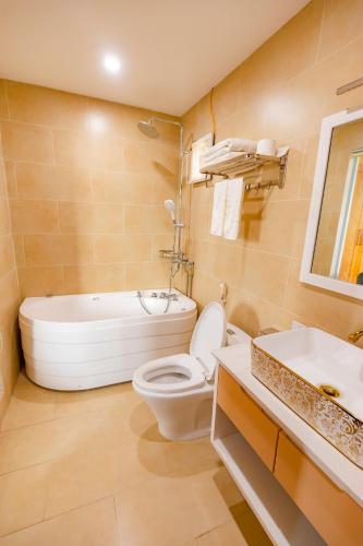 a bathroom with a tub and a toilet and a sink at Hoa Viên Hotel - Suối khoáng Kim Bôi in Hòa Bình