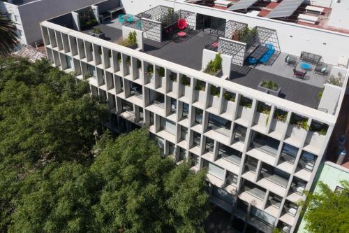 an overhead view of a white building with trees at NIU Modern & Centric Lofts in Mexico City