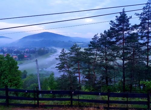 a view of a mountain with a fence and trees at Widokówka Myczkowce in Myczkowce