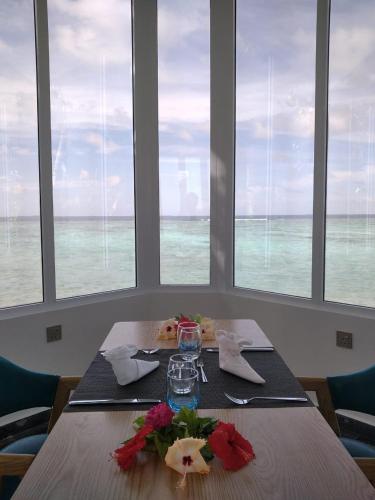 a table in a room with a view of the ocean at Island Life Maldives Retreat & Spa in Magoodhoo