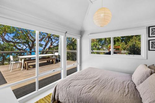 洛恩的住宿－Retro Beach Vibes，一间卧室配有一张床,阳台配有桌子