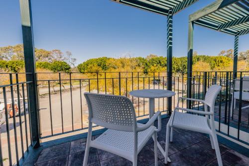 a patio with two chairs and a table on a balcony at Joondalup Resort in Perth
