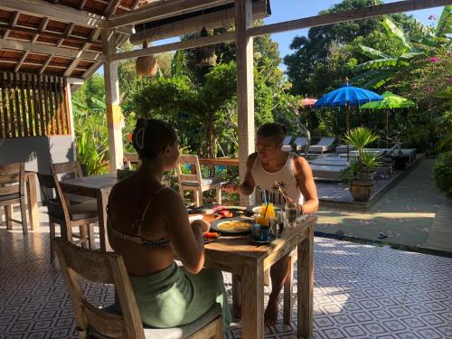 two women sitting at a table in a restaurant at Le Biu garden View in Nusa Lembongan