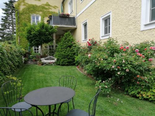 um quintal com uma mesa e cadeiras em frente a uma casa em Hotel Die Residenz em Schloss Rosenau