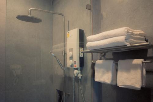 a bathroom with a towel rack with towels at Into the town krabi in Krabi town