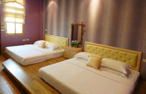 a bedroom with two beds and a mirror at Family Pottery in Hengchun
