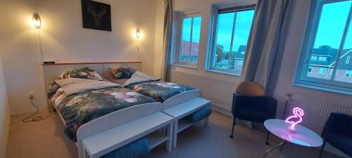 - une chambre avec un lit, une table et des fenêtres dans l'établissement Airbnb 'Logeren aan het plein' in het centrum van Meppel, à Meppel