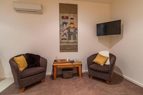 a living room with two chairs and a table at Balconies Dolphincove in Tura Beach