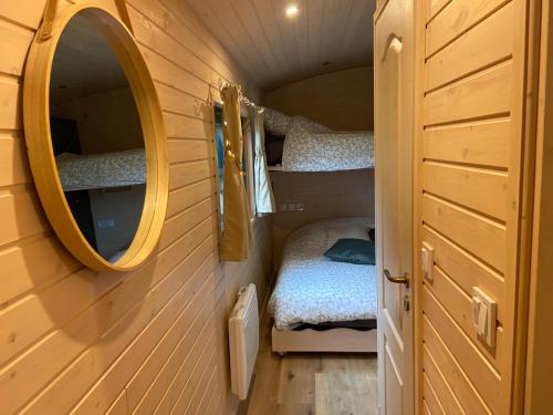 a small bedroom with two bunk beds and a mirror at La roulotte de bonneval in Charleval