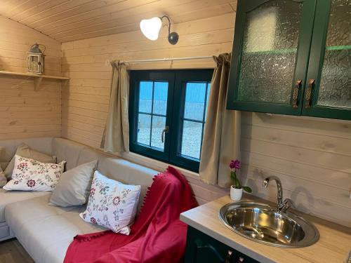 a living room with a couch and a sink at La roulotte de bonneval in Charleval