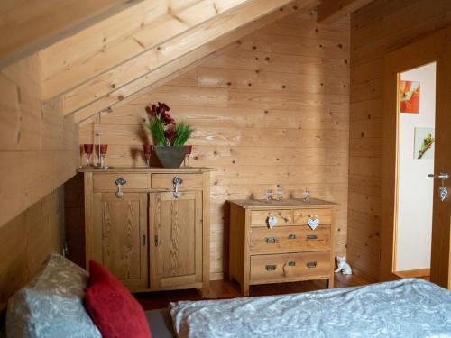 a bedroom with a bed and a wooden wall at Ferienhaus Friedrichsblick in Lug