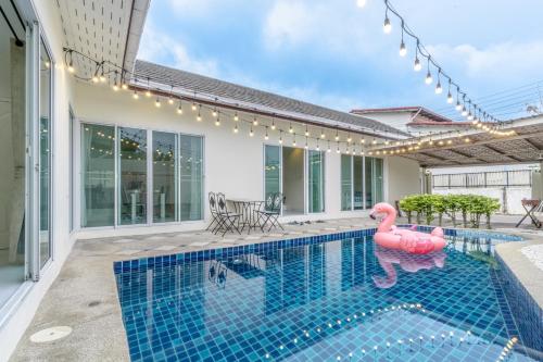 a swimming pool with a pink flamingo in a house at Peacock Pool Villa in Nong Prue